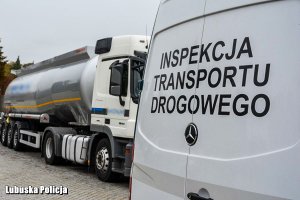 napis Inspekcja Transportu Drogowego na drzwiach samochodu, w tle ciężarówka