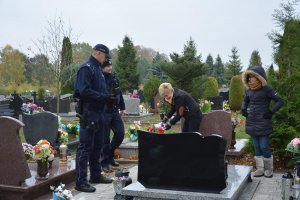policjanci rozmawiają z odwiedzającymi groby
