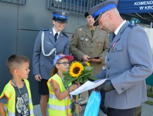 Komendant otrzymuje kwiaty i życzenia od dzieci z przedszkola