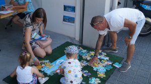 Dzieci z dorosłymi układają puzzle