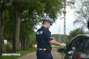 policjant wręcza kierującemu mandat karny