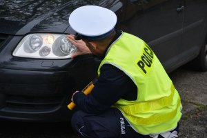 policjant kontroluje oświetlenie pojazdu