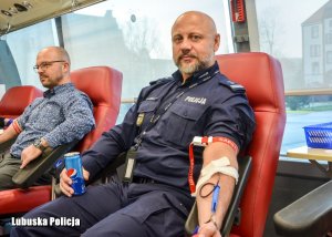 mężczyzna i policjant oddają krew