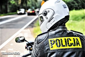 napis policja na kurtce policjanta w kasku motocyklowym