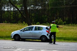 policjant daje znak do zwolnienia prędkości