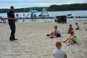 policjant podczas spotkania z dziećmi nad jeziorem