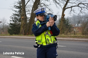 policjantka kontroluje prędkość jadących pojazdów