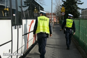 policjanci idą obok autobusu