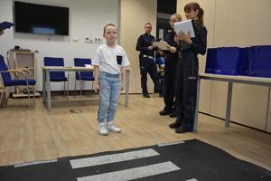 policjanci wyjaśniają  dziecku zadanie do wykonania
