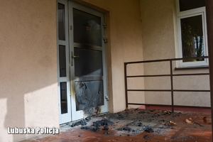 podpalone drzwi i ślady spalonych materiałów na schodach
